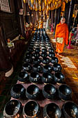 Chiang Mai - The Wat Phan Tao temple, Inside the Wihan: the 108 alm bowls for collecting the offers of coins. 